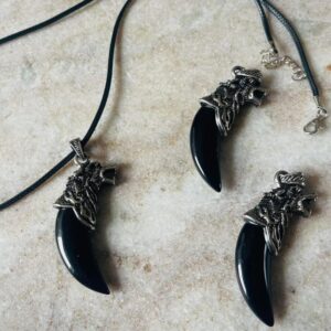 Ulvehoved halskæde med sort obsidian-tand (ca. 5 cm). Støtter beskyttelse, transformation og grounding. Inkl. vokset snor med stål lås.