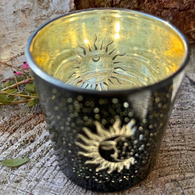 Fyrfadsstage i sort glas med gylden sol med ansigt og små glitrende stjerner.