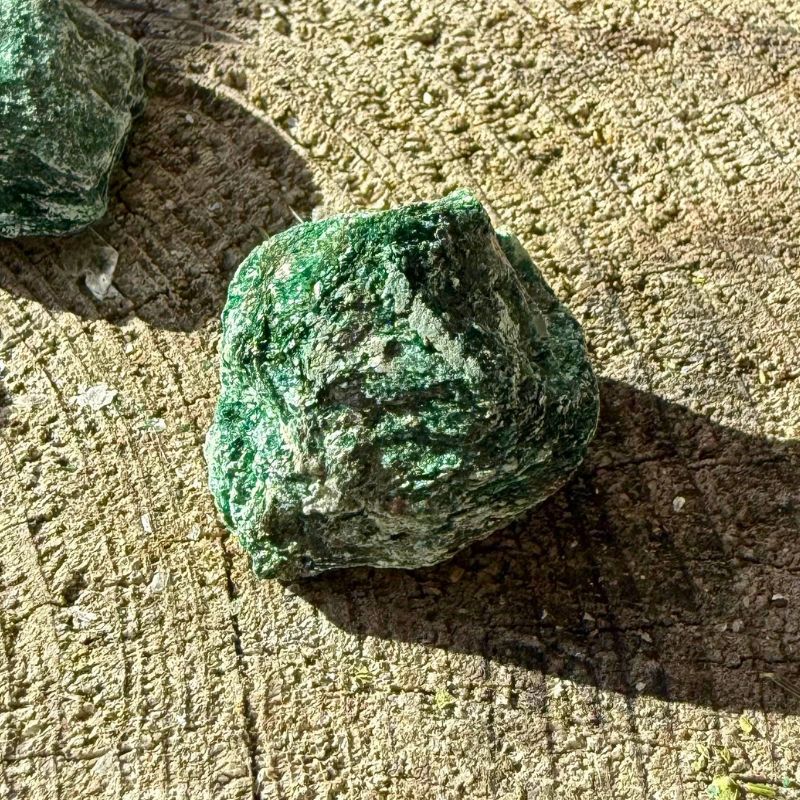 Nærbillede af rå grøn Fuchit med fine glimmerlag og ujævn overflade