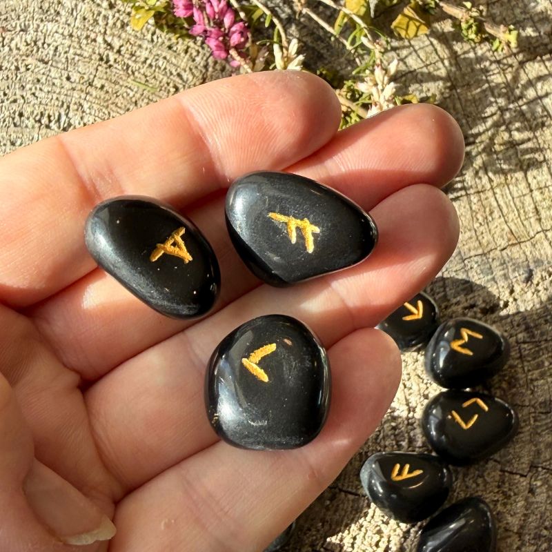 Sorte obsidian runesten med nordiske runesymboler til runelæsning
